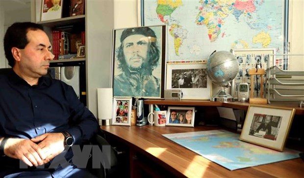 Anh Ahmet Yazar với những tấm ảnh Bác Hồ được đặt trân trọng trên bàn làm việc. (Ảnh: Hương Giang/TTXVN)